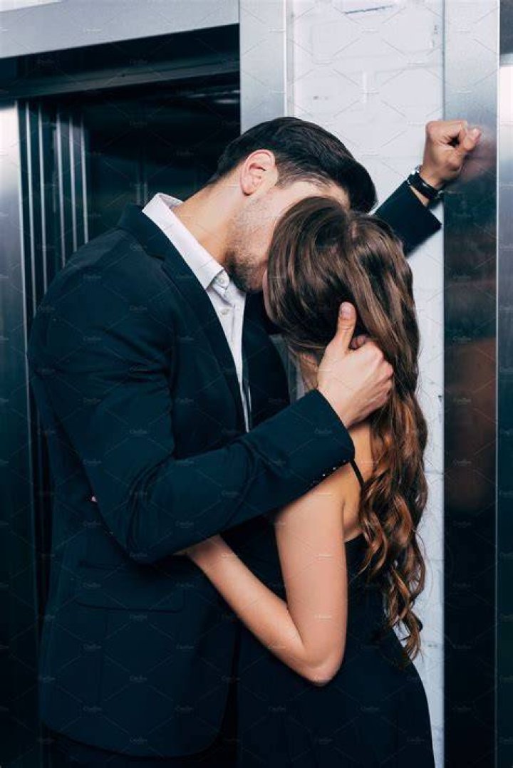 Enchanting Moment: Man And Woman In Elevator's Embrace